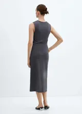Vestido midi color beige, sin mangas y con detalle de nudo en la cintura.