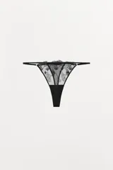 Tanga negra con cintura elástica fina y detalle de encaje floral.