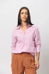 Camisa celeste a rayas verticales blancas, de corte recto y mangas largas con puños abotonados.