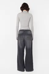 Top manga larga gris de punto roma, con media polera y cuello con cierre de nylon a tono. Mangas con mitones en los puños y estampa de isologo con serigrafía al tono en el delantero.