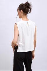 Blusa blanca sin mangas con cuello redondo y corte crop.