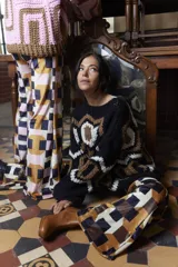 Sweater tejido a mano en lana merino, con cuello redondo y diseño geométrico en colores negro, blanco y marrón. De calce holgado y talle único.