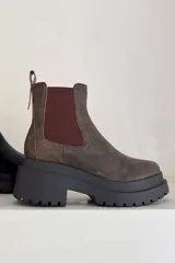 Bota Chelsea color marrón con elástico lateral color borgoña y suela track de goma negra.