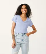Blusa blanca de algodón con cuello en V, manga corta y bolsillo frontal.