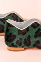 Botines bajos con estampado animal print en tonos verde y negro, con escote en V y borlas decorativas en el empeine.