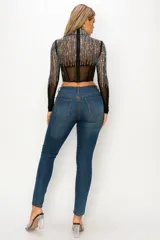 Top tipo corset de tul elastizado semi transparente color negro, con cuello alto y mangas largas. Cubierto con pedrería plateada.