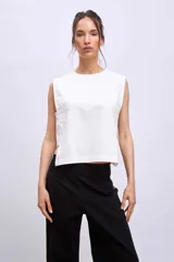 Blusa blanca sin mangas con cuello redondo y corte crop.