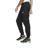 Pantalón de jogging negro de corte ajustado con puños elásticos, bolsillos laterales y bolsillo cargo con solapa en el muslo derecho. Logo de Nike bordado en blanco en el muslo izquierdo.