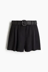 Short negro de sarga con pinzas, tiro alto, cinturón trenzado ancho, cierre con botón y corchete ocultos, bolsillos laterales y traseros.
