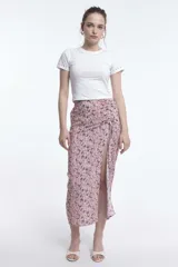 Remera blanca de algodón con cuello redondo y mangas cortas, con detalle de tachas plateadas en cuello y mangas.