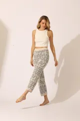 Pantalón de punto color crema con estampado de ondas azules.
