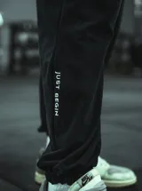 Pantalón de jogging gris melange, corte oversize, con cintura elástica ajustable con cordón y puños ajustados. Estampado en la pierna izquierda con la frase "Just Begin".