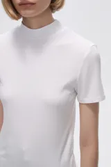 Remera blanca de viscosa con cuello alto y manga corta.