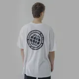 Remera blanca de algodón con estampa circular en la espalda que contiene un globo terráqueo y la frase "Bad Decisions Club Member".