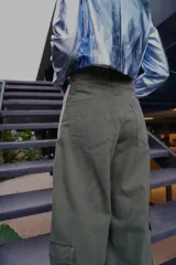 Pantalón ancho verde oliva con bolsillos cargo y aplique de cinta con rayas blancas en los laterales.