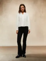 Camisa blanca de manga larga con textura arrugada, cuello mao y puños elásticos.