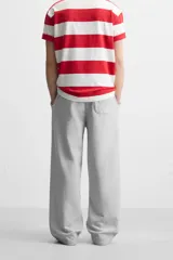 Pantalón jogger negro de corte ancho, confeccionado en tejido de algodón con interior de rizo. Cuenta con cintura elástica ajustable con cordón interior, bolsillos laterales y bolsillo trasero de parche.