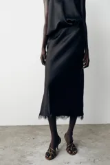 Falda midi negra de satén con cintura elástica y detalle de encaje en el ruedo.
