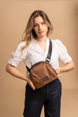 Bandolera pequeña de tela negra, con correa ancha ajustable y cierre superior.