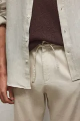 Pantalón de lino color crema, con cintura elástica y cordón ajustable.