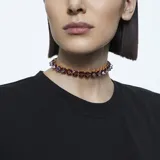 Gargantilla con cristales tridimensionales de talla piramidal en tonos violetas, con montura con baño dorado y engaste abierto. Cierre de seguridad. Forma parte de la familia Chroma.