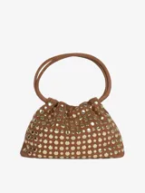 Mini bolso cubo marrón con tachuelas doradas, confeccionado en cuero y detalles metálicos. Incluye una correa para llevar al hombro o en la mano. Se cierra con broche magnético.