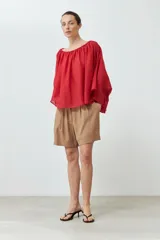 Blusa roja con escote bardot y mangas largas amplias.