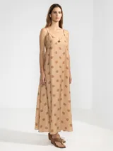 Vestido largo hasta el tobillo de viscosa y poliamida, con estampado de rayas verticales rosas y flores rojas. Tiene breteles finos, escote en V profundo y detalle de flor Polonio en cobre.