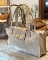 Bolso tote marrón con textura símil cocodrilo, cierre dorado y doble asa de mano.