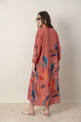 Vestido largo de lino color verde militar con estampado de hojas en tonos azul, naranja y marrón. Tiene cuello mao con botones, mangas tres cuartos y un bolsillo en el pecho.