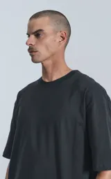 Remera negra de corte crop y calce oversize, con hombros caídos y cuello redondo.