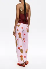 Pantalón de jean color lila con estampado de cactus marrones con flores naranjas. Corte recto, tiro medio y largo tobillero.