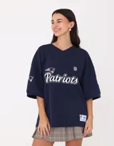 Camiseta de fútbol americano azul marino con cuello en V y mangas cortas. Estampado frontal con el logo y nombre del equipo New England Patriots. Incluye logo de la NFL en el pecho y parches con el logo del equipo en las mangas.