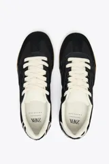 Zapatillas deportivas negras con detalle de estampado animal en la parte trasera, suela color caramelo y ajuste con cordones.
