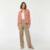 Chaqueta vaquera rosa con botones dorados, cuello clásico, cierre frontal con botones, dos bolsillos con solapa en el pecho y corte recto.