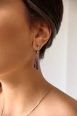Aros colgantes de acero quirúrgico hipoalergénico con dije de piedra natural en forma de gota color azul oscuro.