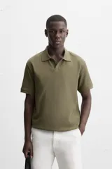 Polo azul marino de punto con textura acanalada vertical, corte regular fit, cuello solapa con abertura frontal y mangas cortas.