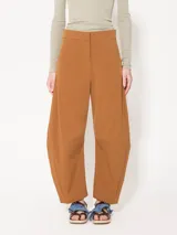 Pantalón color marrón confeccionado en poplin 4way. Incluye bolsillos laterales y ojales en la parte trasera, con presillas en la cintura para ajuste. Acceso mediante cierre, gancho pantalonero y botón interno.
