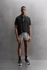 Camiseta deportiva verde militar confeccionada en tejido estructurado, ligero y elástico. Tiene cuello redondo, manga corta y bajo con aberturas laterales. Incluye logo estampado en el bajo.