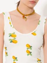 Musculosa blanca con estampado de limones, confeccionada en tejido de punto acanalado. Presenta escote en V tanto en delantero como en espalda, bien cavados para un look femenino y estilizado.