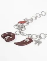 Collar plateado de cadena gruesa con dijes colgantes de estrella, corazón, herradura y cuerno.