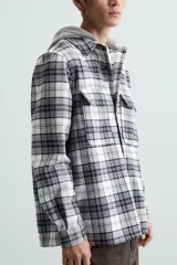 Sobrecamisa de hombre a cuadros azul marino y blanco, corte relaxed fit, con capucha gris de algodón, cuello solapa, manga larga con puños abotonados, bolsillos de parche en el pecho y bolsillos laterales en la cadera.