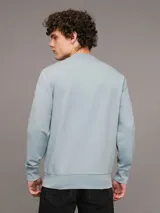 Buzo celeste de cuello redondo, marca Calvin Klein, con logo CK bordado en el pecho.
