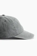 Gorra gris de sarga de algodón con ojales bordados, trabilla ajustable y cierre de metal en la parte trasera.