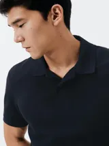 Camiseta tipo polo de manga corta, color azul oscuro, con cuello y tapeta de dos botones.