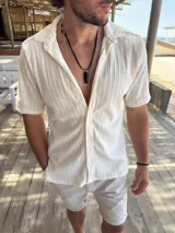 Camisa color crema de tejido trenzado con cuello tipo cubano y mangas cortas.