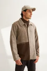 Camisa estilo leñadora con diseño patchwork en tonos marrones y beige. Presenta coderas, cartera americana y bolsillo ojal en el delantero. Confeccionada en Uruguay con tela 100% lana fina sin teñir.