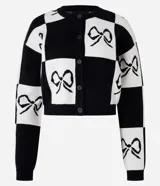 Cardigan corto de punto con bloques de color blanco y negro, con estampa de lazos y cierre con botones.