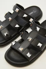 Sandalias negras con plataforma y tiras gruesas con apliques de tachas piramidales plateadas.