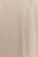 Pantalón negro de tiro alto con pinzas delanteras, pernera ancha y cinturón con hebilla dorada.